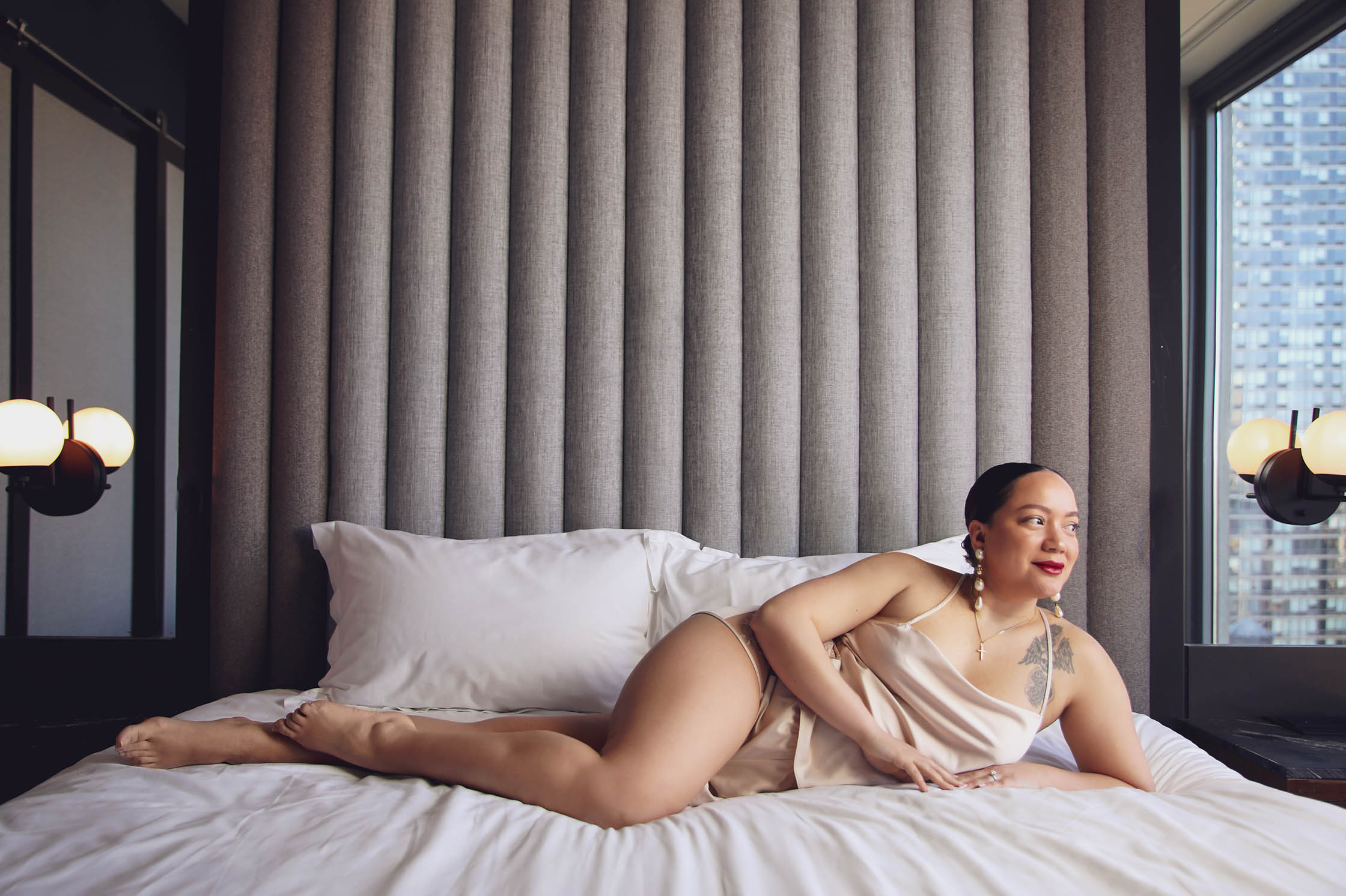 Client posing for a boudoir photo on bed